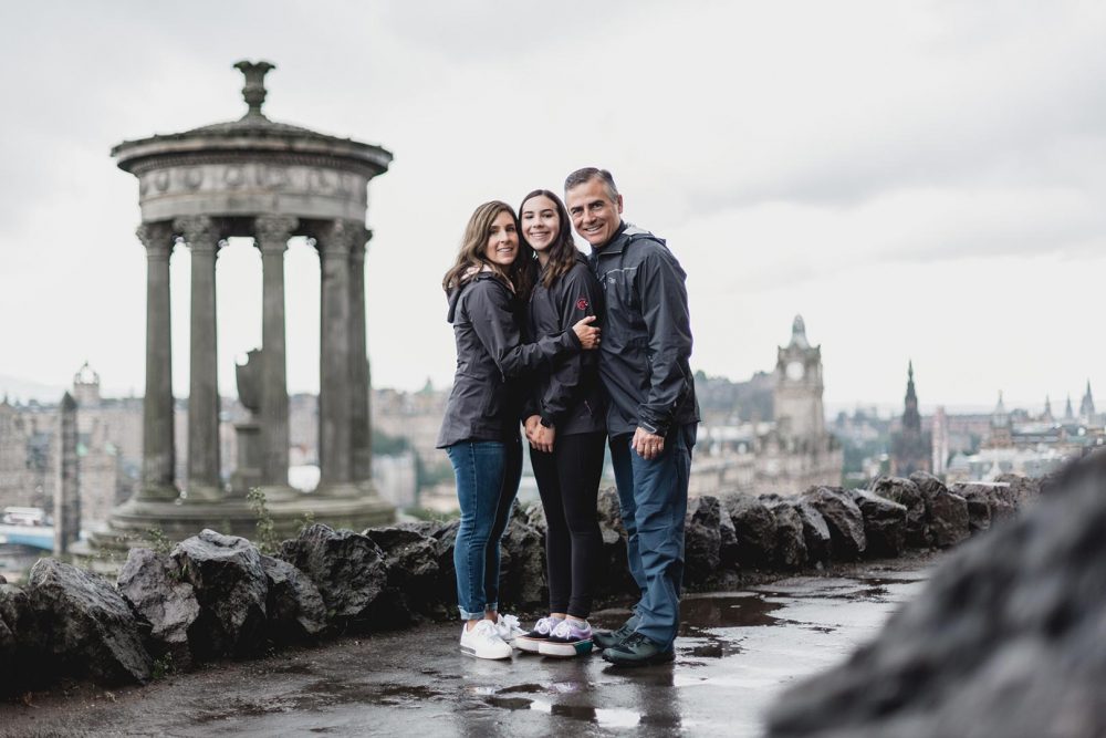 photo of a family standing on calton hill with beautiful view of Edinburgh in the background