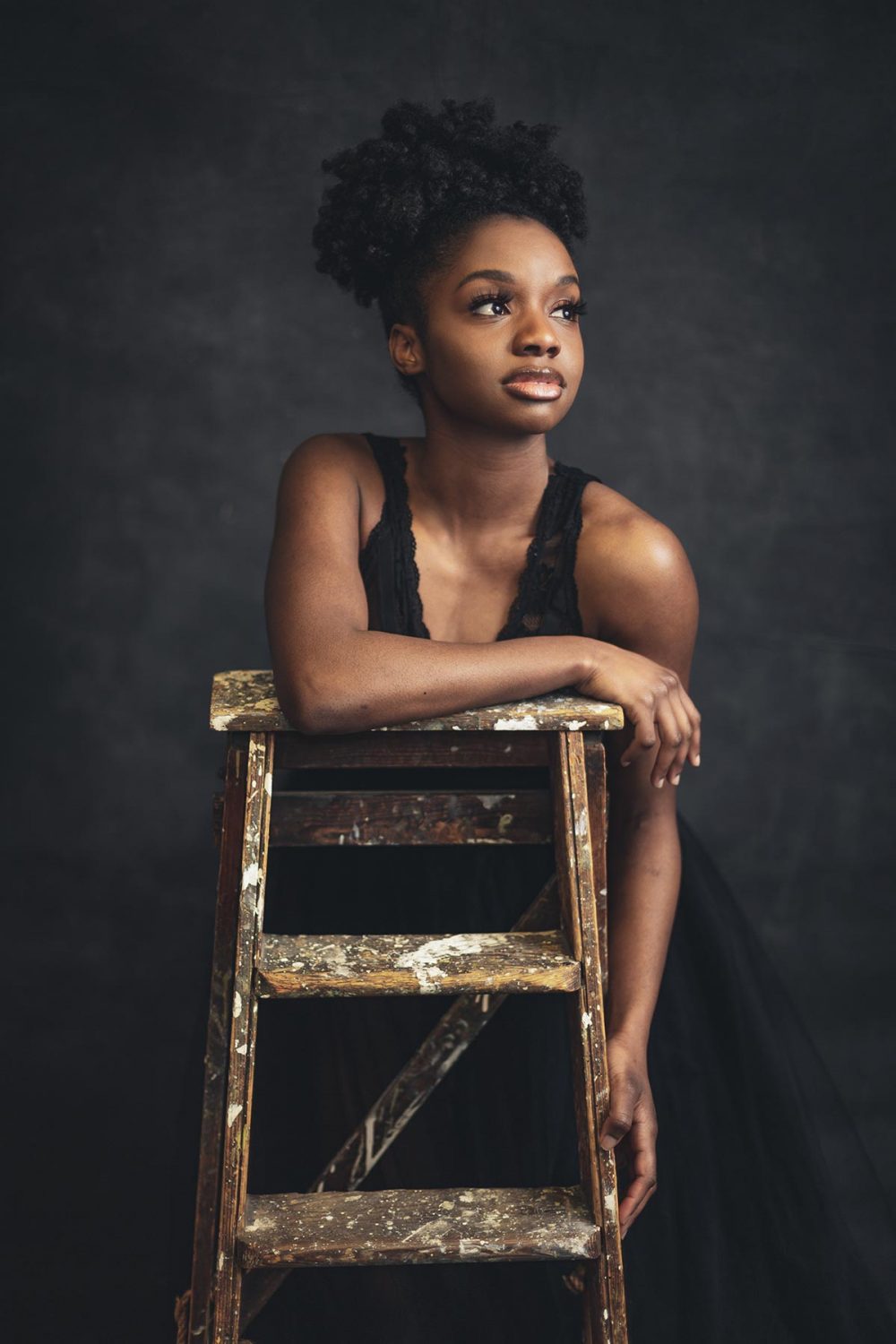 young black woman leaning over a ladder